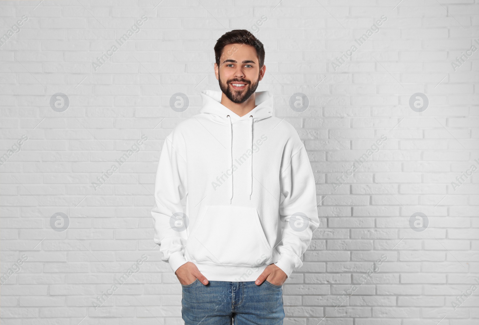 Photo of Portrait of young man in sweater at brick wall. Mock up for design