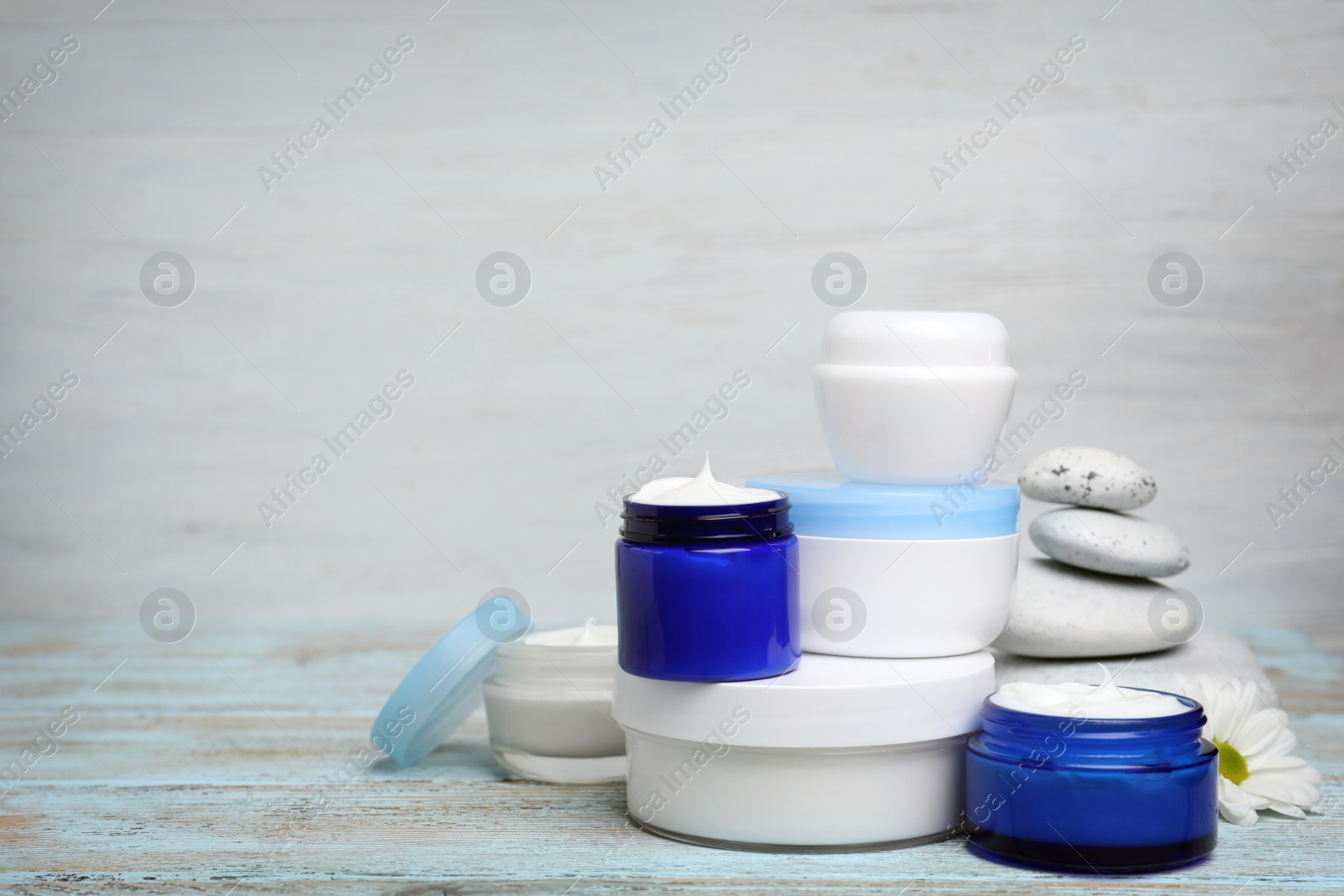 Photo of Composition with body cream in jars on light background