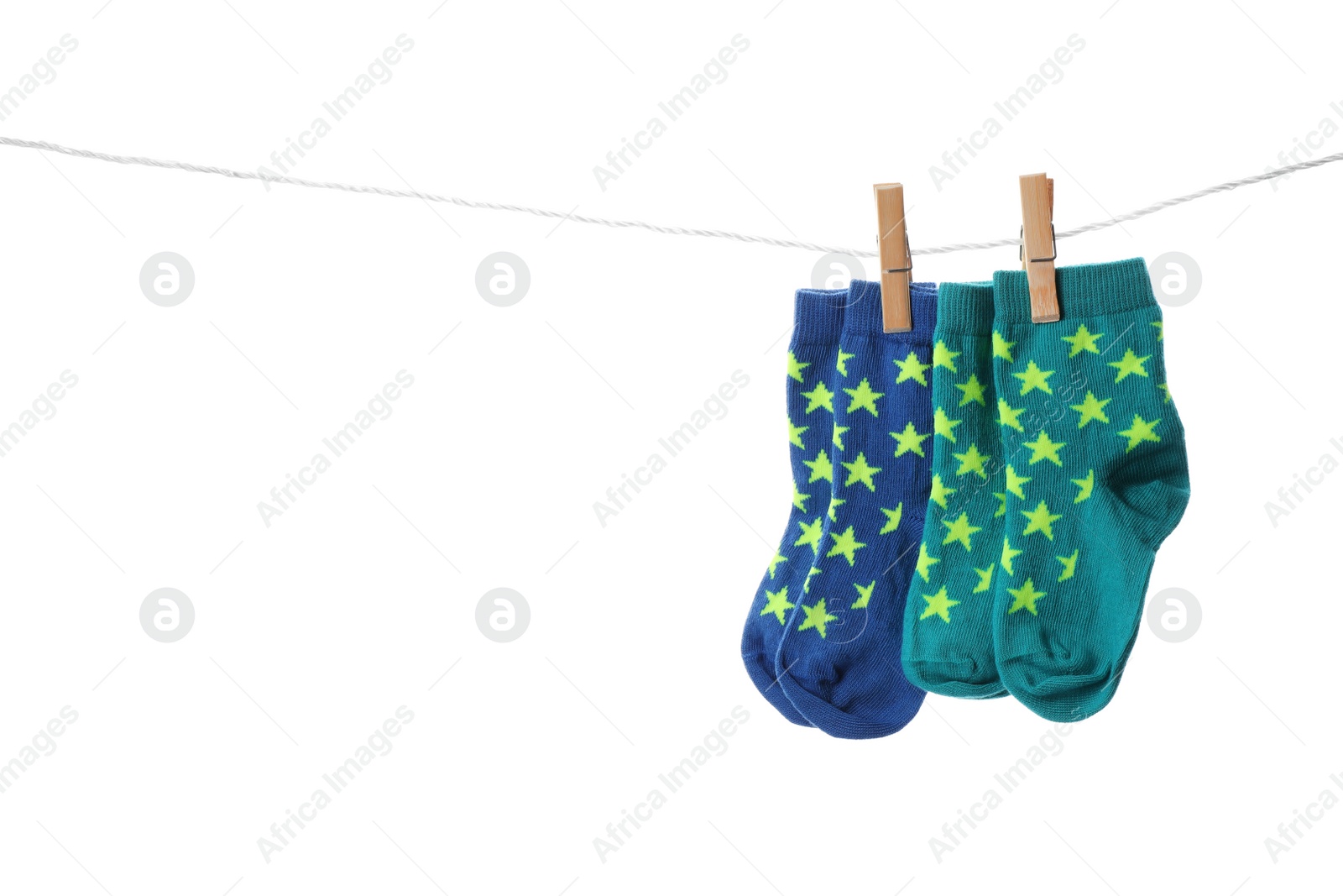 Photo of Cute child socks on laundry line against white background