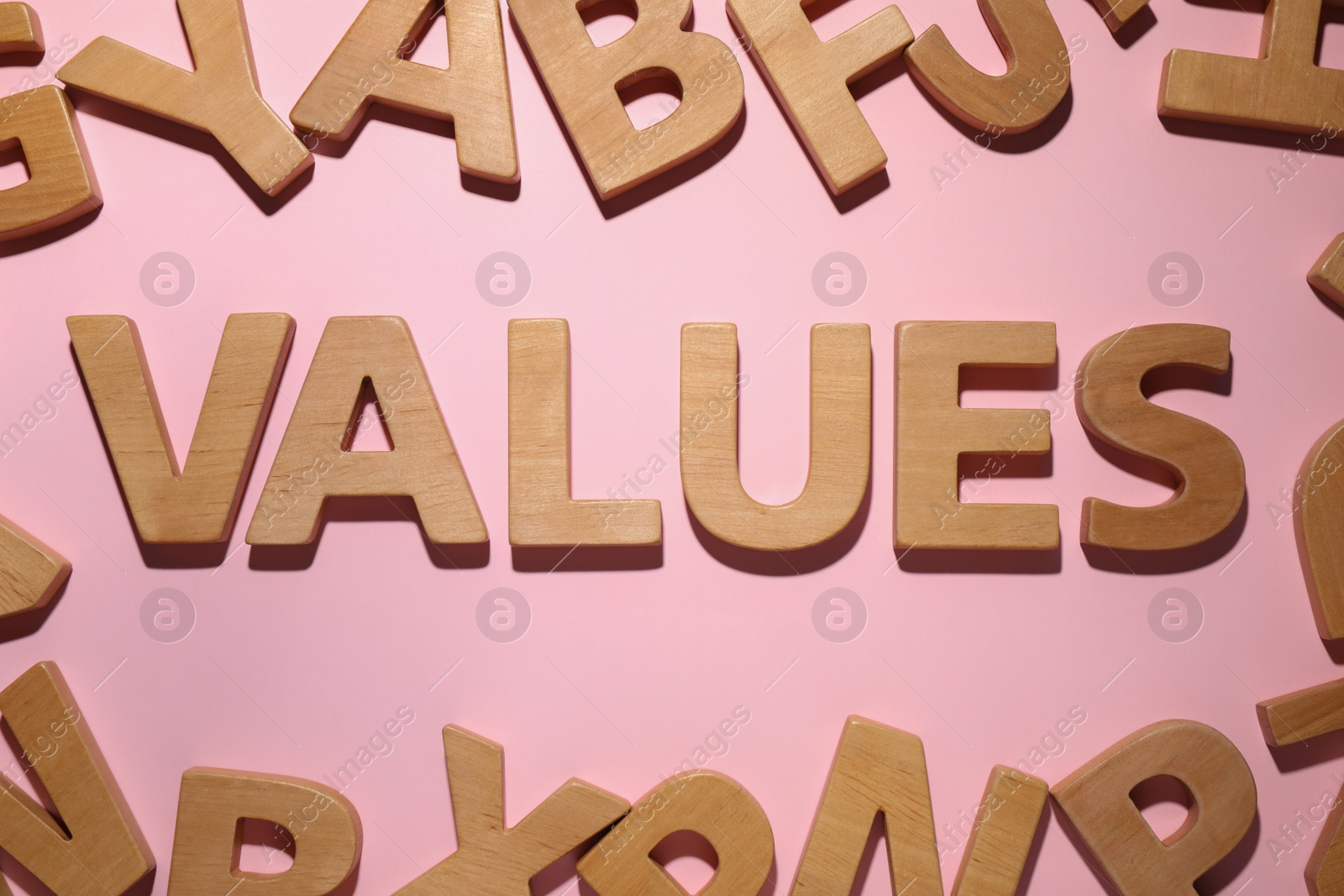 Photo of Word VALUES made of wooden letters on pink background, flat lay