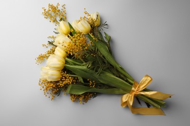 Photo of Bouquet with beautiful tulips and mimosa flowers on light grey background, top view