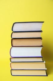 Collection of hardcover books on yellow background