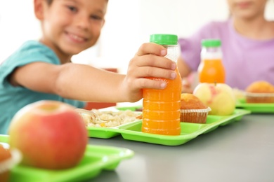 Photo of Children sitting at table and eating healthy food during break at school, closeup
