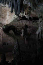 Picturesque view of many stalactite and stalagmite formations in dark cave