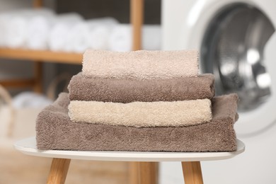 Photo of Folded soft terry towels on white table indoors