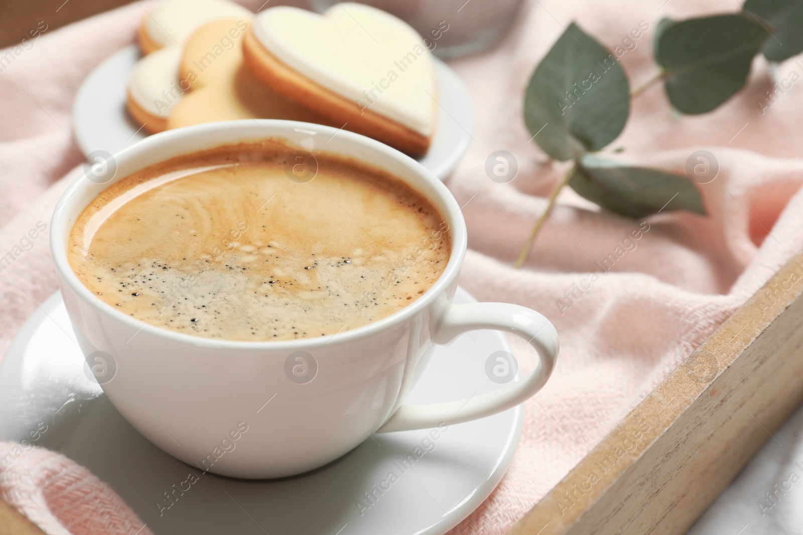 Photo of Aromatic coffee on wooden tray, closeup. Tasty breakfast