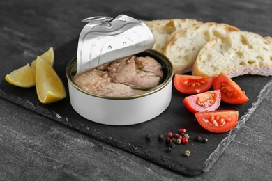 Open tin can of tasty cod liver and different products on black table