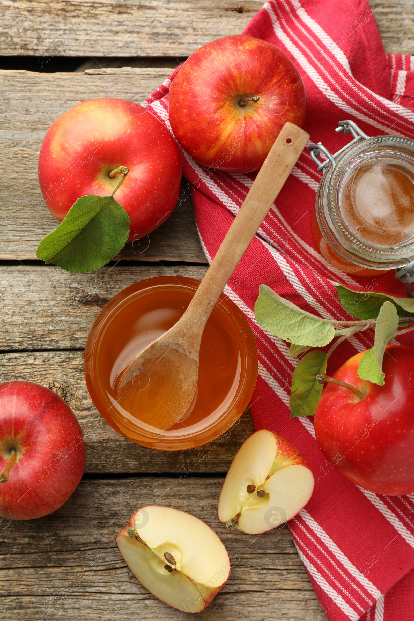 Photo of Sweet honey and fresh apples on wooden table, flat lay