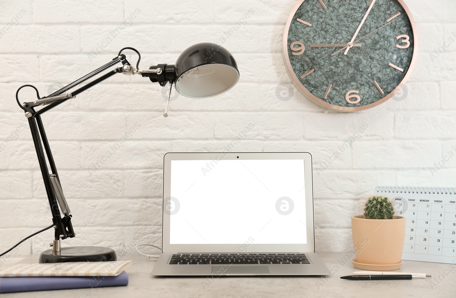 Photo of Stylish workplace with lamp and laptop on table