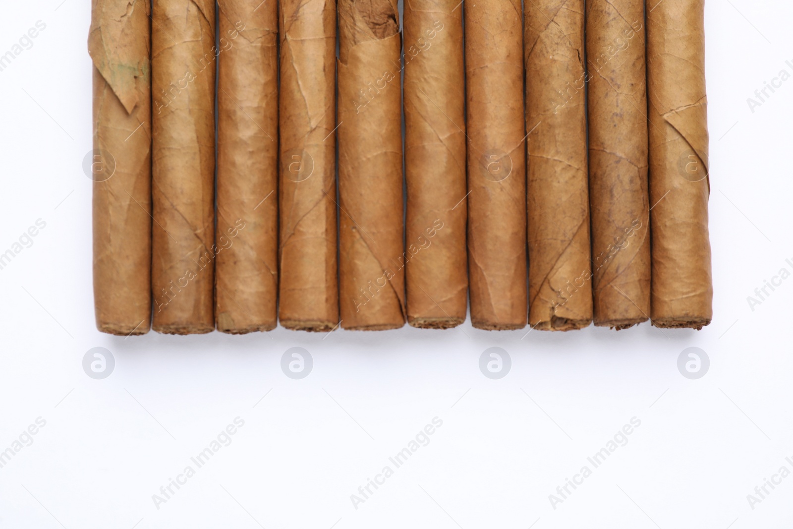 Photo of Many expensive cigars on white background, top view