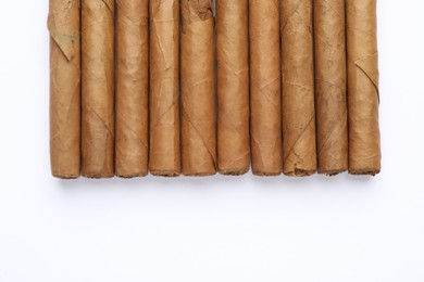 Photo of Many expensive cigars on white background, top view