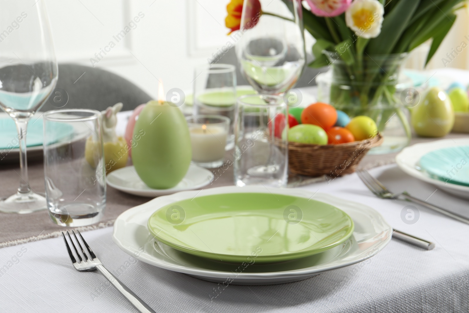 Photo of Easter celebration. Festive table setting with elegant dishware and painted eggs