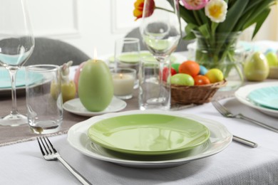 Easter celebration. Festive table setting with elegant dishware and painted eggs