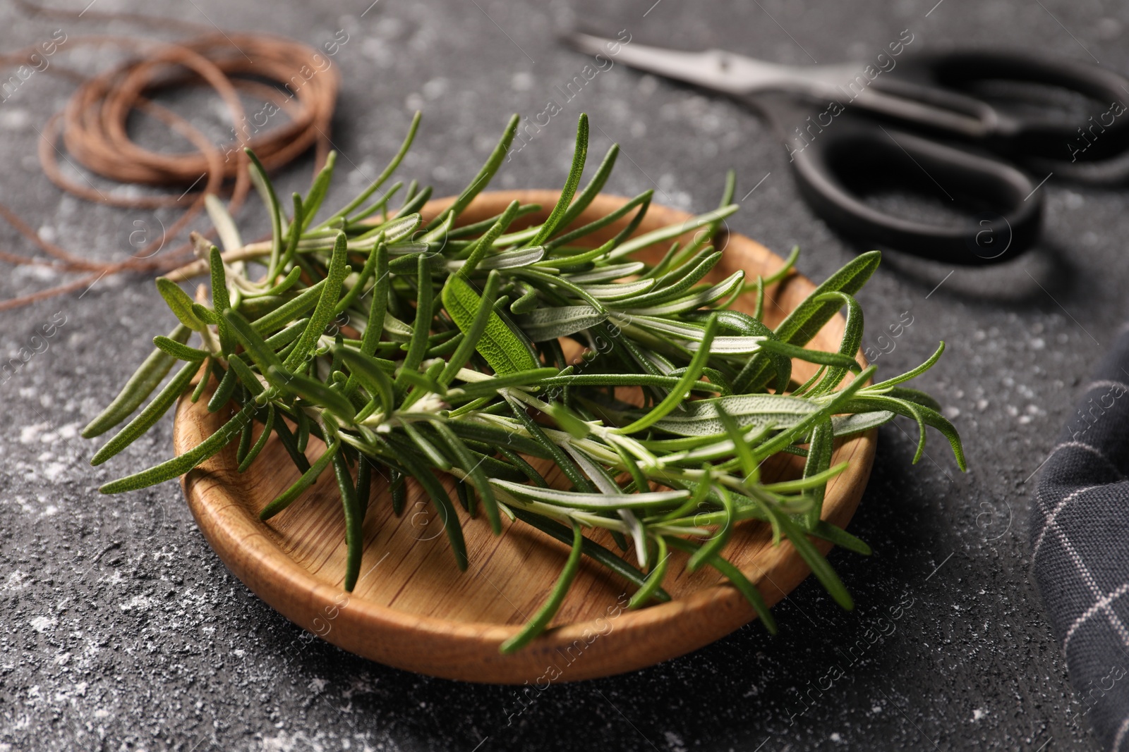 Photo of Fresh rosemary on grey textured table, closeup