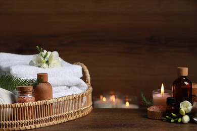 Photo of Beautiful composition with different spa products and burning candles on wooden table. Space for text