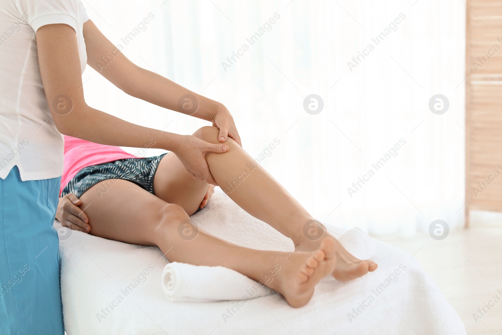 Photo of Woman receiving leg massage in wellness center