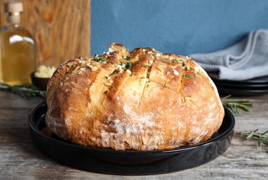 Plate with delicious homemade garlic bread on table