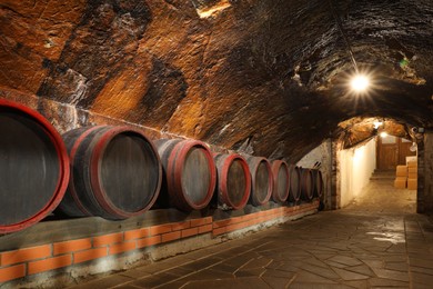 Photo of Beregove, Ukraine - June 23, 2023: Many wooden barrels with alcohol drinks in cellar