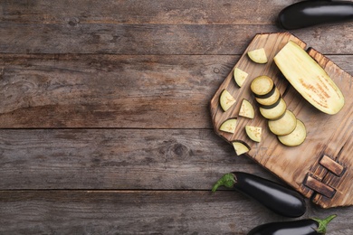 Photo of Flat lay composition with ripe eggplants on wooden background