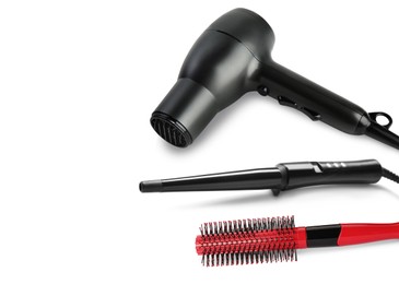 Image of Hair dryer, curling iron and brush on white background