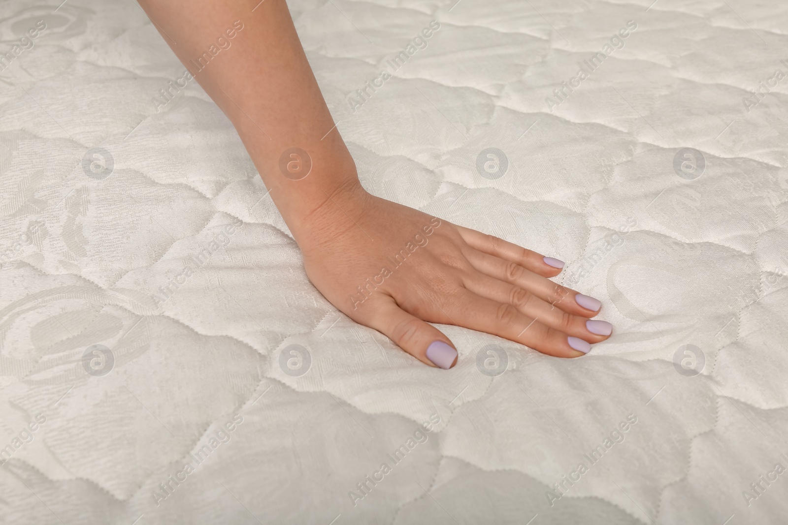 Photo of Woman touching soft comfortable mattress, closeup of hand