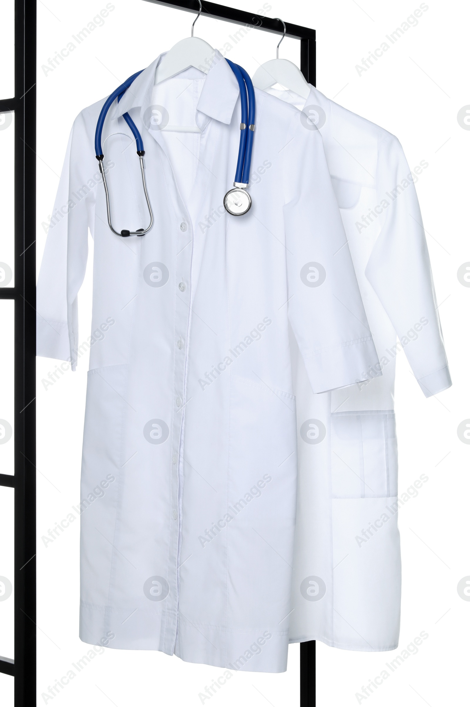Photo of Doctor's gowns and stethoscope on rack against white background. Medical uniform
