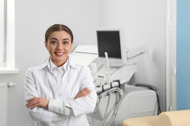 Professional sonographer near modern ultrasound machine in clinic