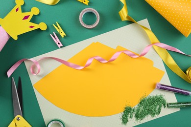 Photo of Handmade party hat. Template and tools on green background, flat lay