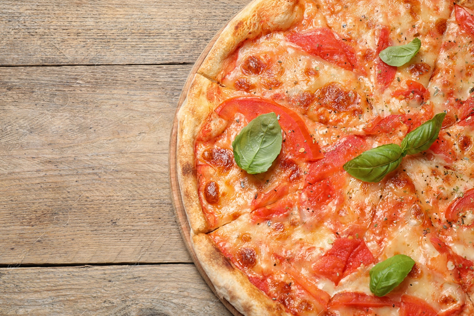 Photo of Delicious pizza Margherita on wooden table, top view. Space for text