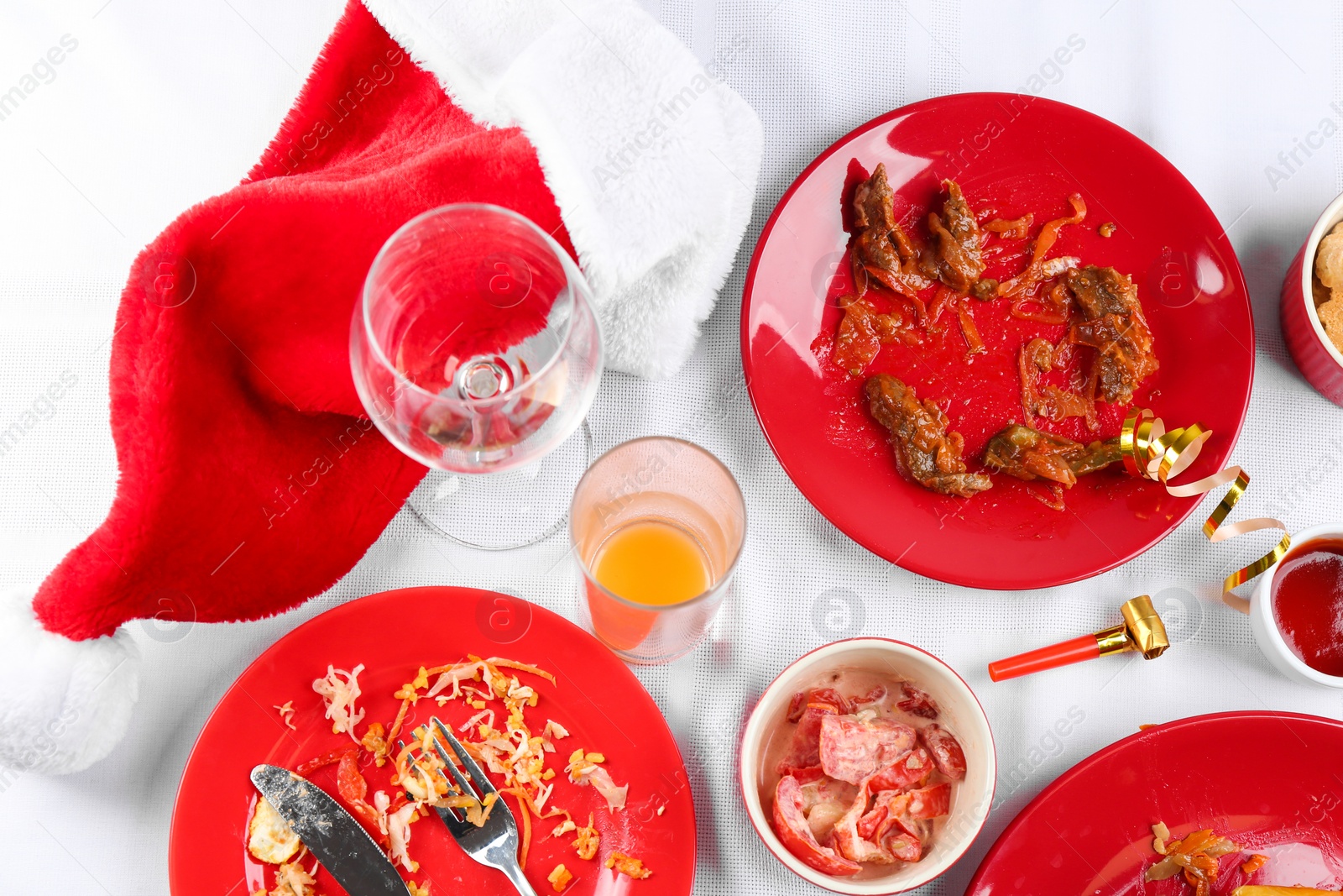 Photo of Flat lay composition with food leftovers on white tablecloth after party