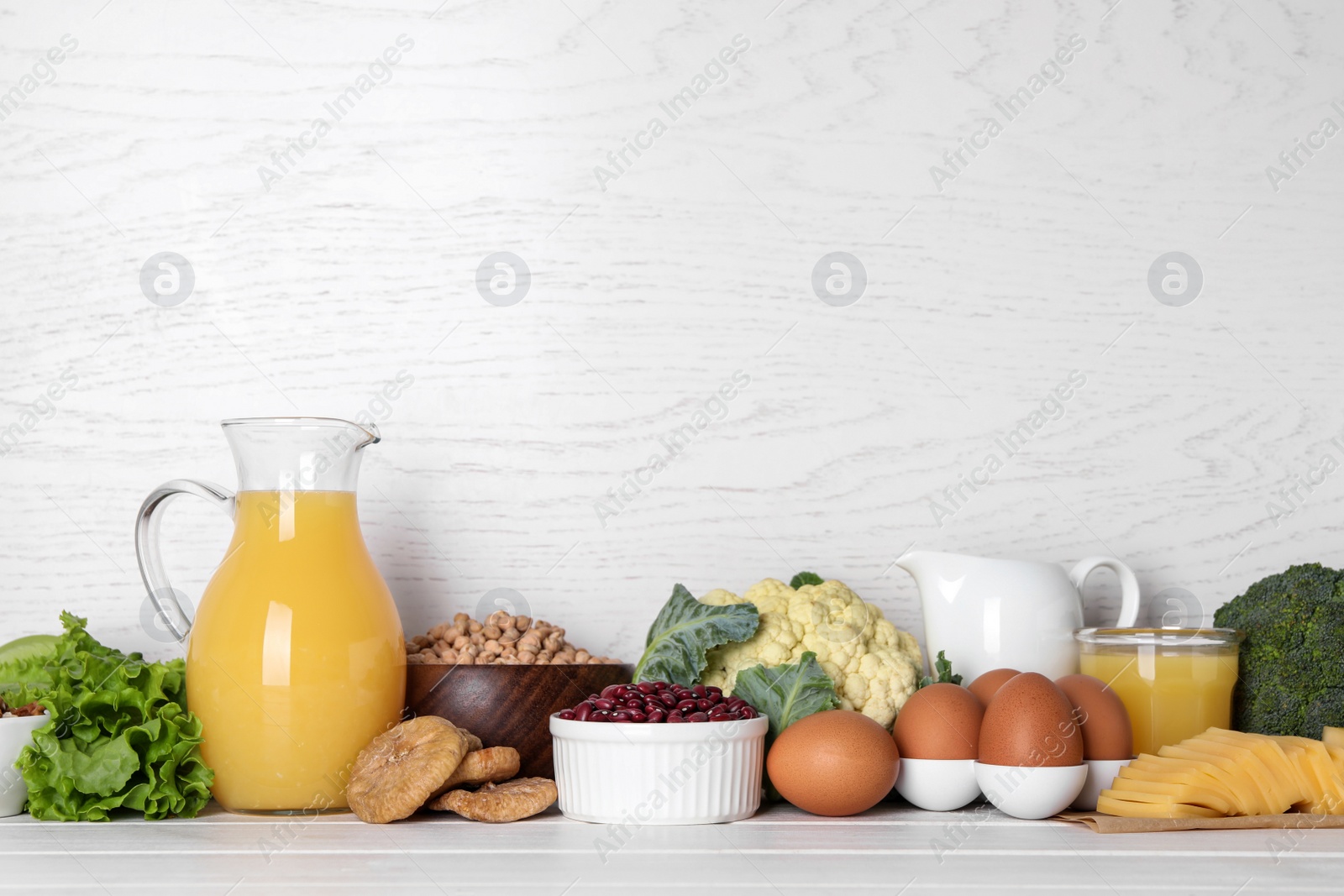 Photo of Food high in calcium. Different products on white wooden table