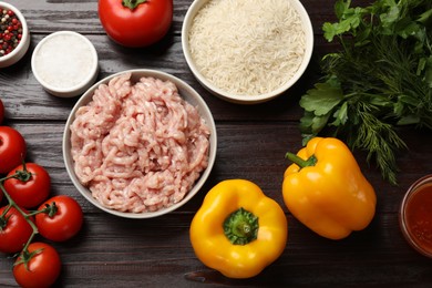 Photo of Making stuffed peppers. Ground meat and other ingredients on wooden table, flat lay