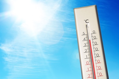 Image of Weather thermometer showing high temperature and blue sky on background