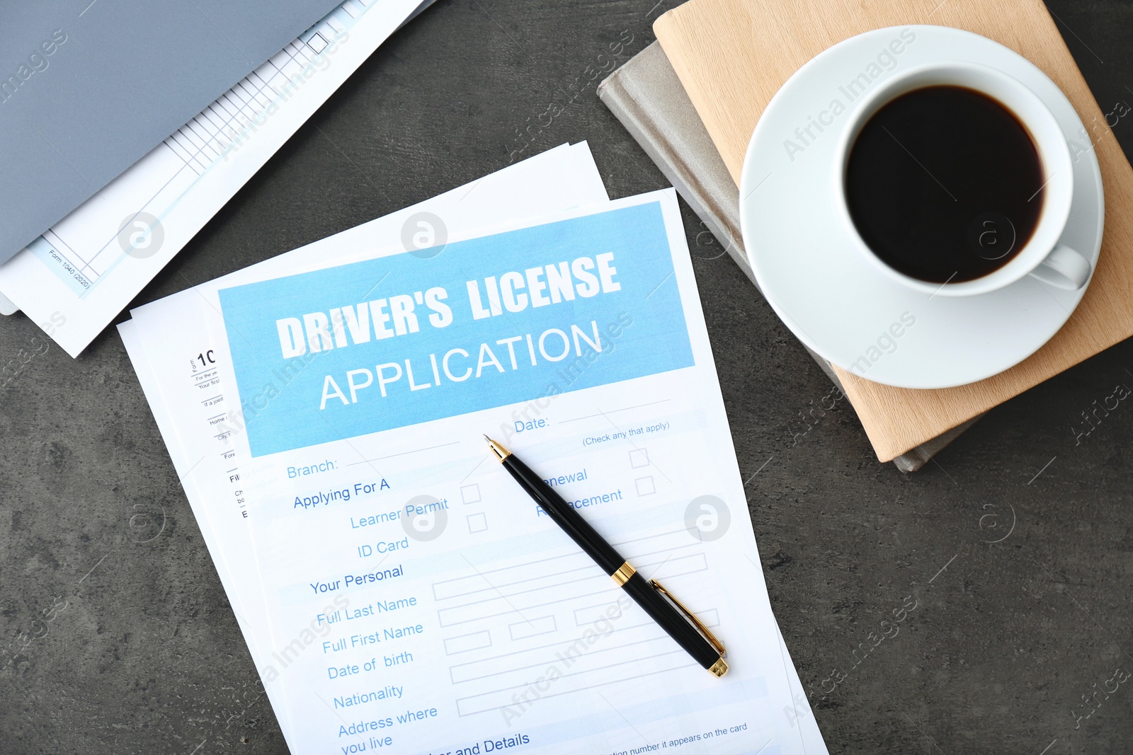Photo of Driver's license application form, stationery and cup of coffee on grey table, flat lay