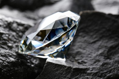 Photo of Beautiful shiny diamond on coal, closeup view