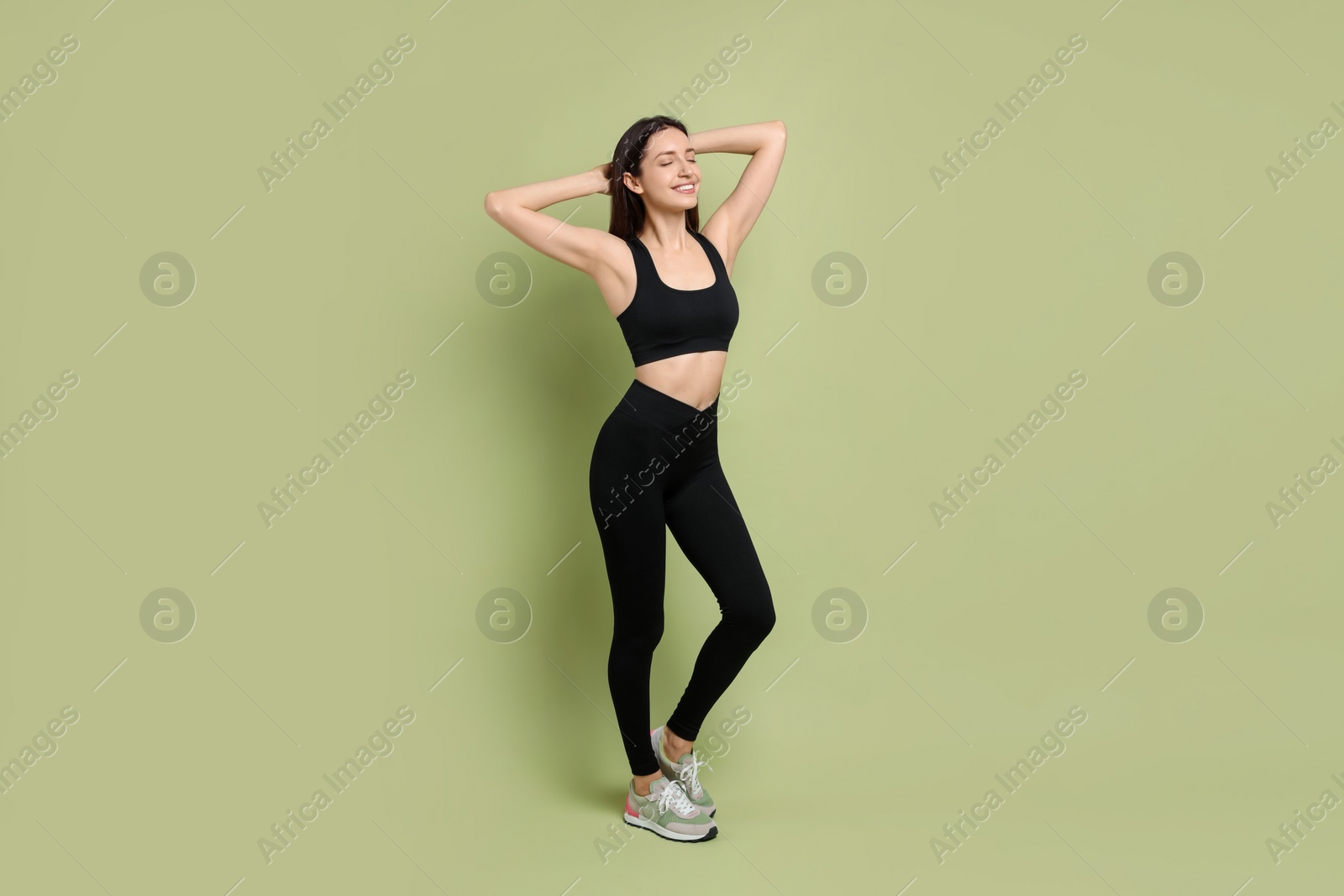 Photo of Happy young woman with slim body posing on green background