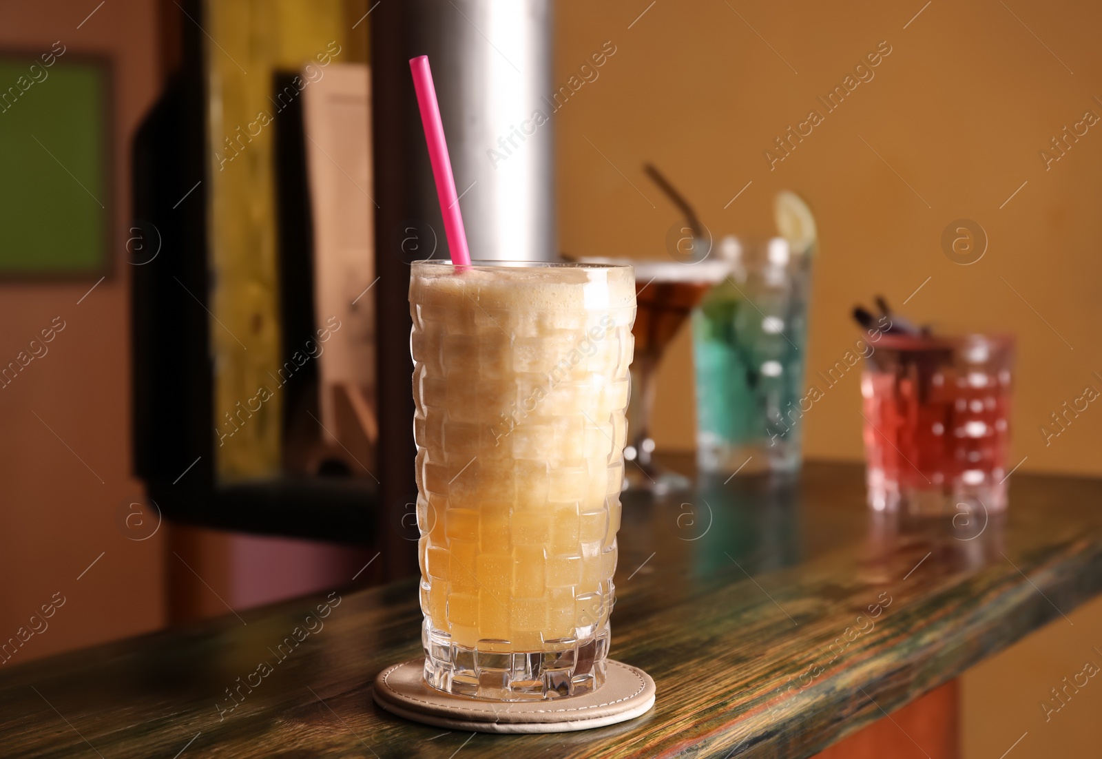 Photo of Glass with delicious cocktail on counter in bar