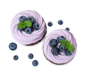 Photo of Sweet cupcakes with fresh blueberries on white background, top view