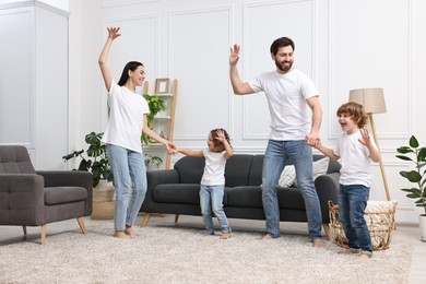 Photo of Happy family dancing and having fun in living room
