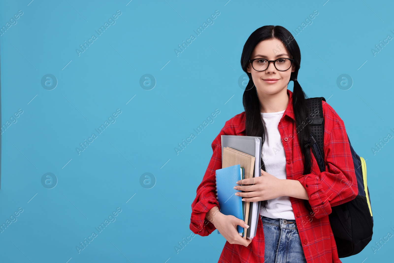 Photo of Student with notebooks, folder and backpack on light blue background. Space for text