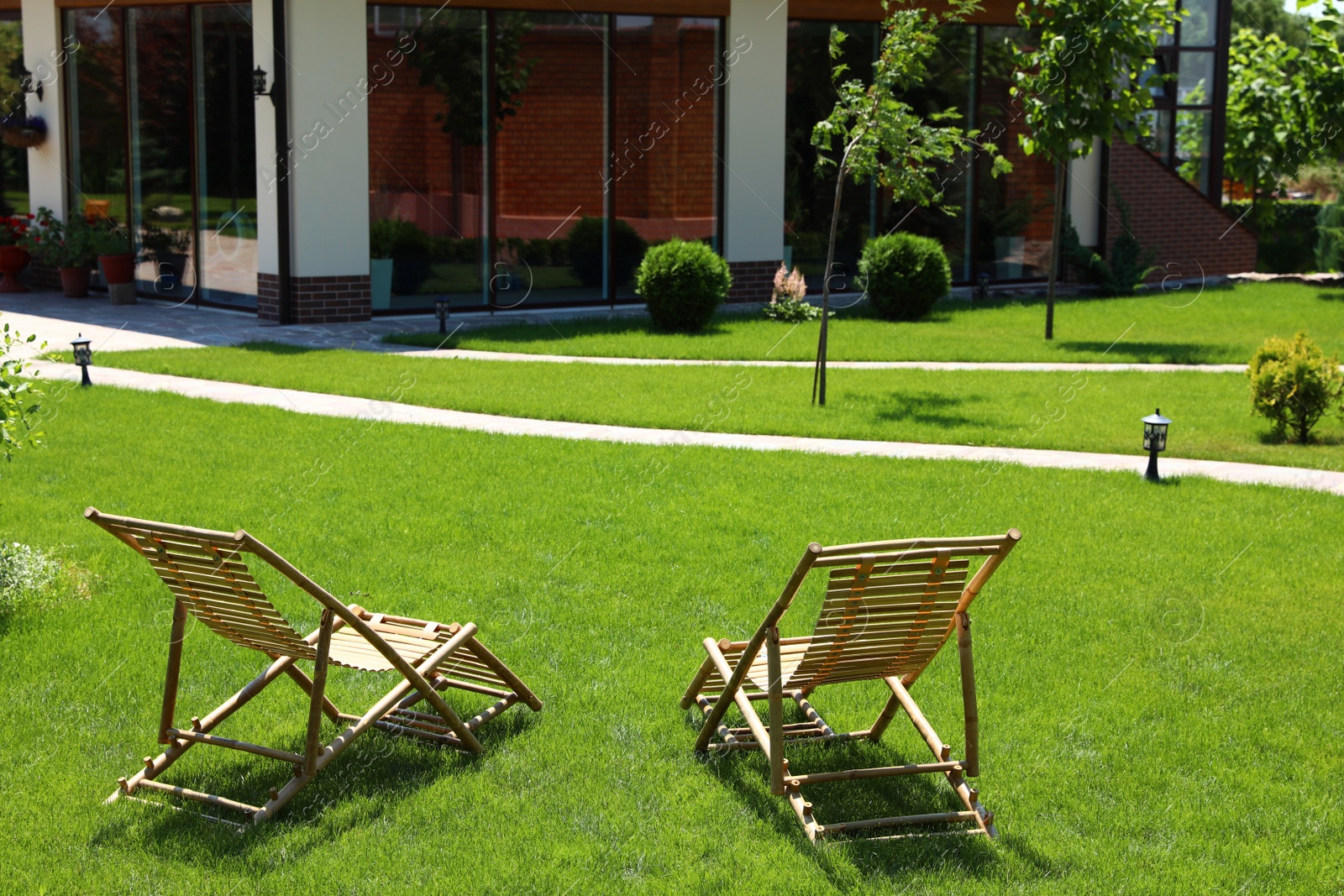 Photo of Wooden deck chairs in beautiful garden on sunny day