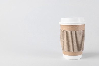 Paper cup with plastic lid on light background, space for text. Coffee to go