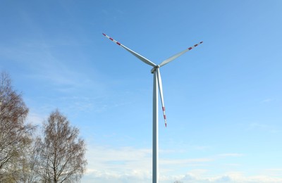 Photo of Modern wind turbines outdoors on sunny day. Alternative energy source