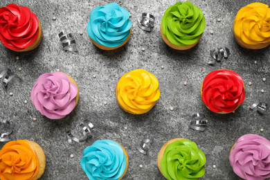 Photo of Flat lay composition with colorful birthday cupcakes on grey table