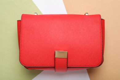 Stylish women's bag on color background, top view