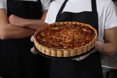 Photo of Sellers with freshly baked quiche in store, closeup