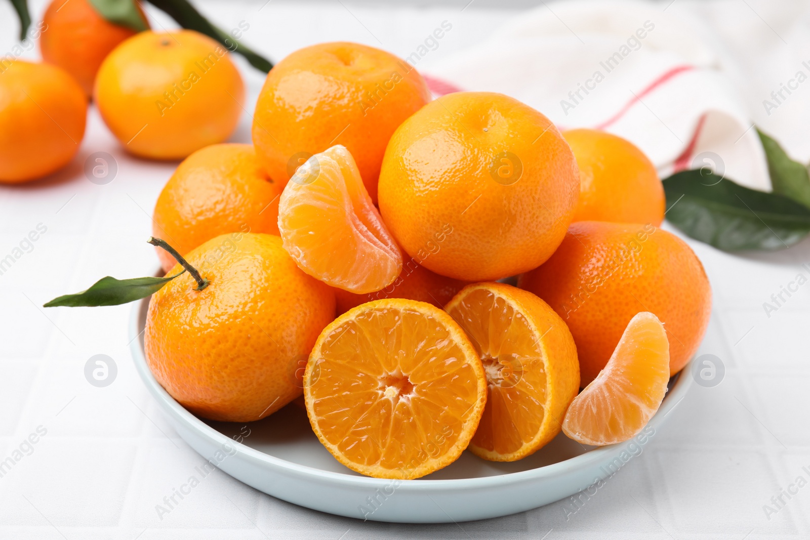 Photo of Fresh juicy tangerines on white tiled table