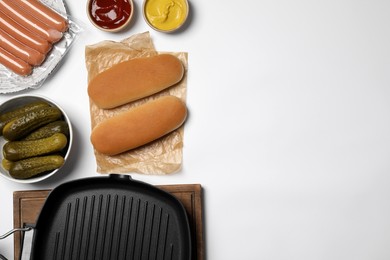 Different tasty ingredients for hot dog and grill pan on white table, flat lay. Space for text