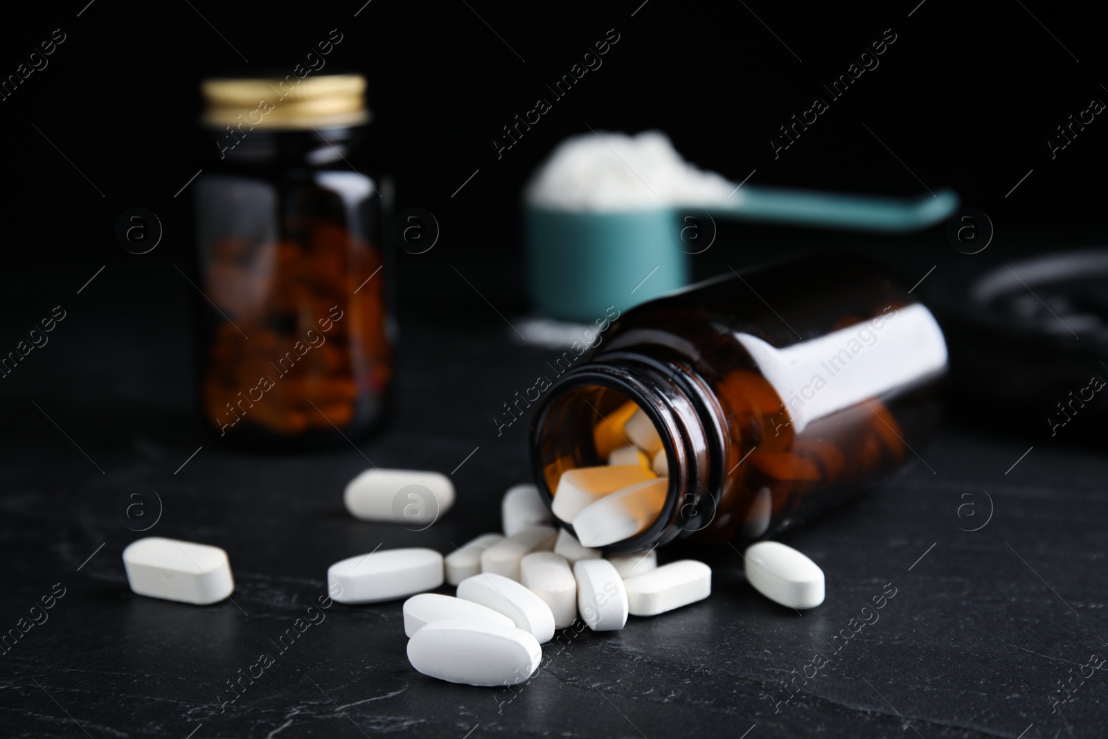 Photo of Bottle and amino acid pills on black table