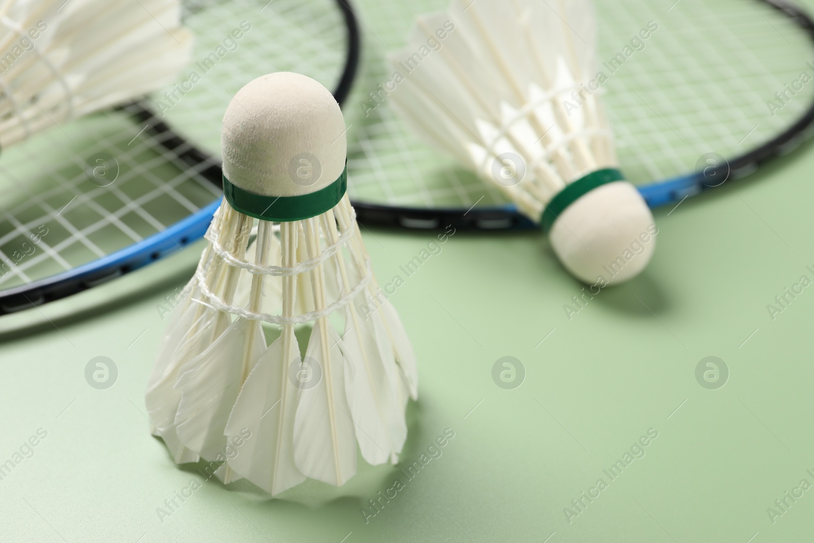 Photo of Feather badminton shuttlecock on green background, closeup